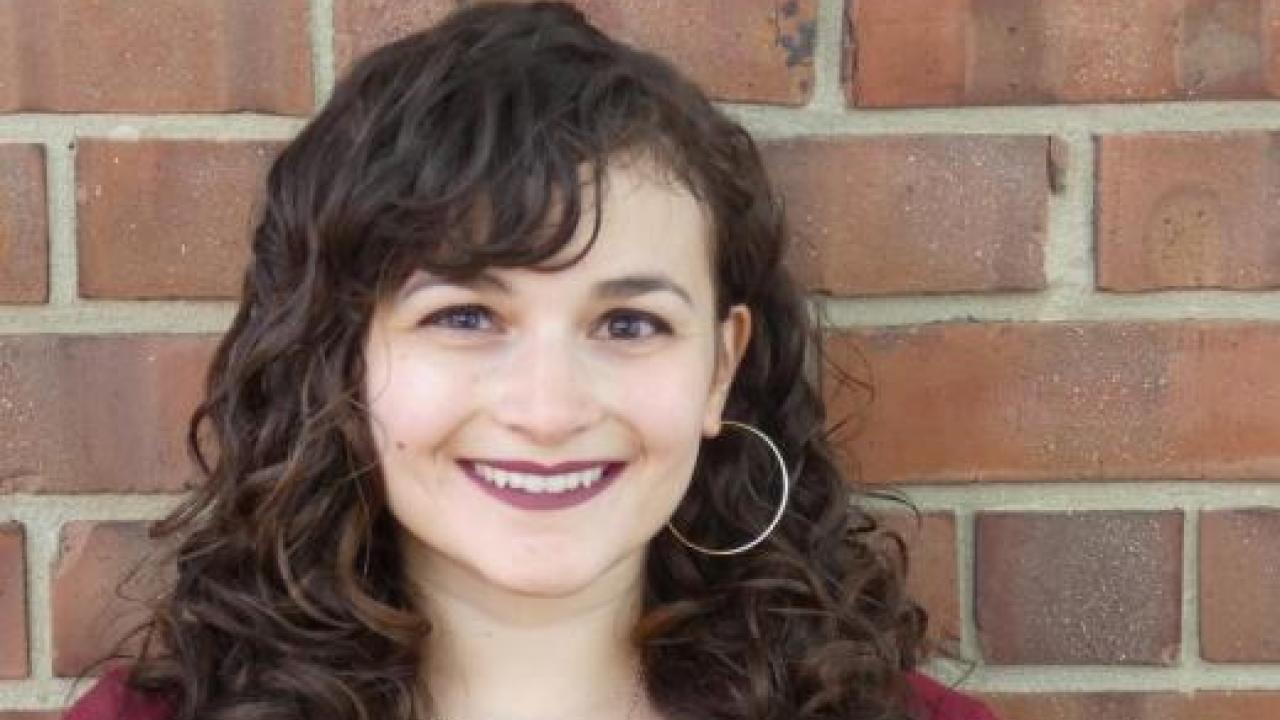 Katie Cruz standing in front of a brick wall