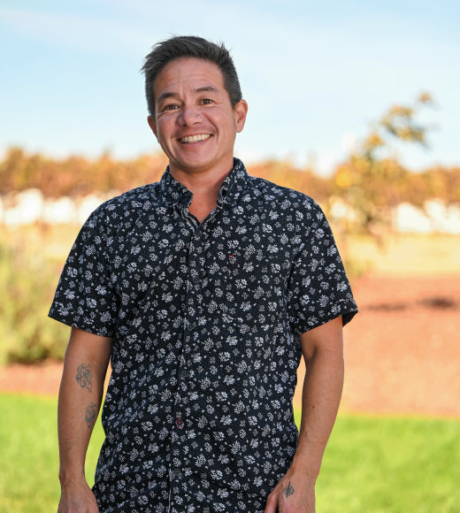 A photo of Professor Chin standing in front of a green lawn