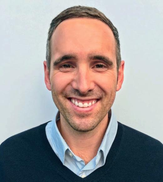 A photo of a man smiling at the camera.