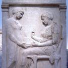 A stone etching of two people.